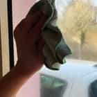 Photo d'une main lavant une vitre